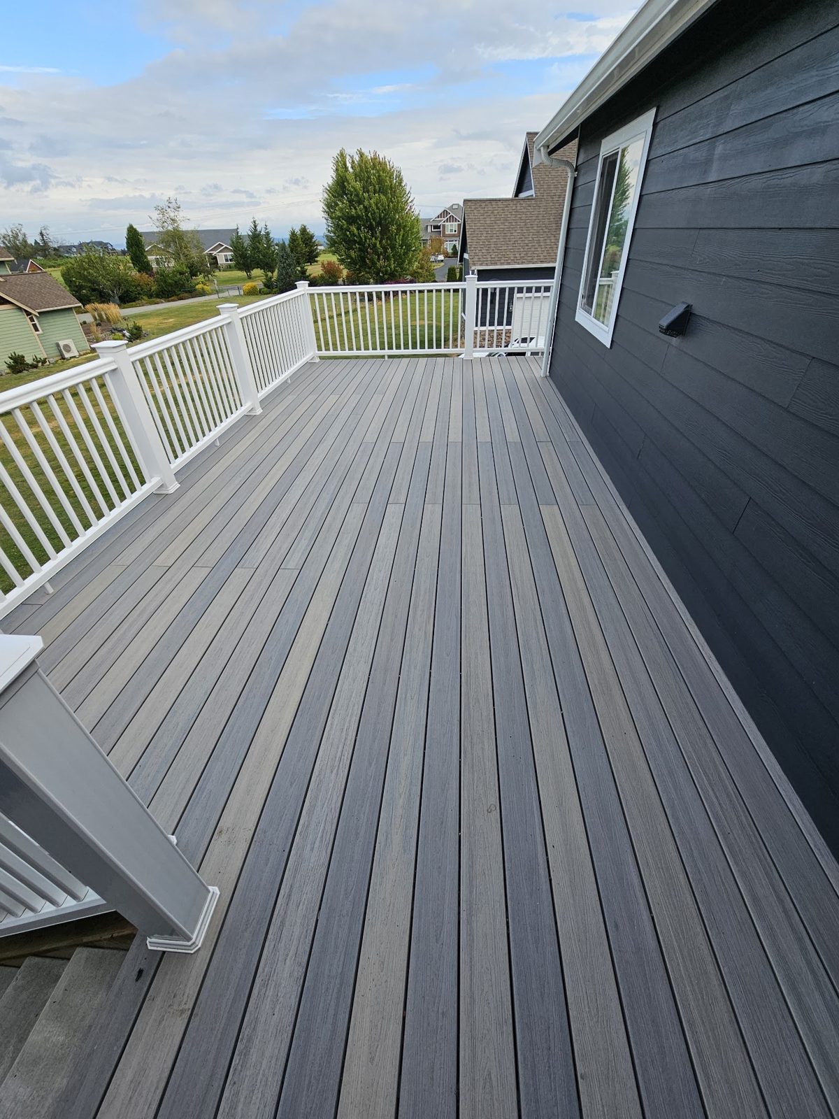 New composite deck with white railing built by Northwest Home Builders in Ferndale