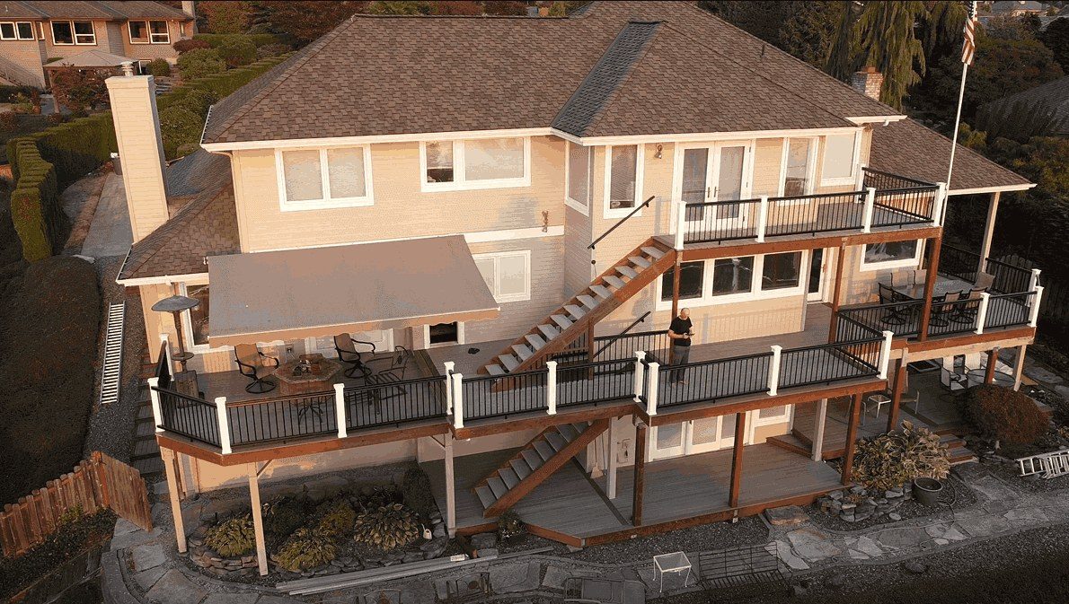 Aerial view of a multi-level deck and stairs wrapping a hillside home
