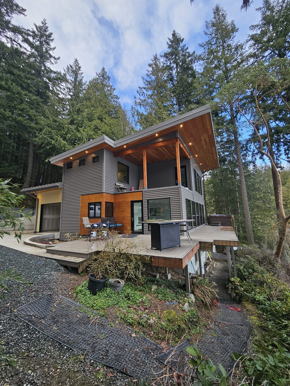 Modern gray home with timber accents built in a wooded Whatcom County lot